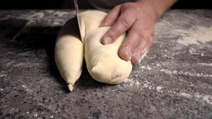 Men's hands hold dough. making raw dough for pizza, rolls or bread. Handmade. Wheat pastries in bakery products. Production of bakery products. Men's hands knead dough. protven or countertop.