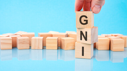 close up image hand of a young businessman holding a wooden cube with letter G. GNI on wooden cube...