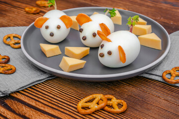 Small chicken eggs mouse,mice with ears of carrot,cheese on plate,creative, fun food,healthy lunch snack idea for kids party. Menu for spooky Halloween dessert treats, edible cute rat selective focus