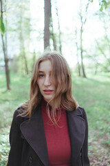 a girl in the woods looking for something. close-up portrait