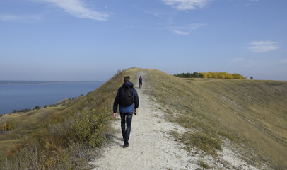 Obraz premium Ulyanovsk Russia, 25 September 2016: A man and a child walk along the ridge of a hill.