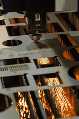 Automatic cnc laser cutting machine working with sheet metal with orange sparks at factory, plant. Metalworking, industrial, equipment, technology, machining, manufacturing concept