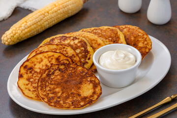 Chorreadas. Corn pancakes made from ground fresh corn served on a plate with with sour cream....