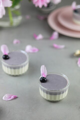Homemade Italian dessert panna cotta with blue berries and peony flowers on gray background....