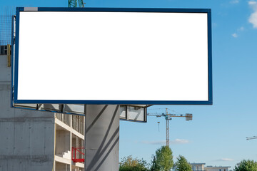 Advertising billboard mock-up near the construction site of modern apartment buildings