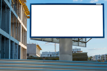 Advertising billboard mock-up near the construction site of modern apartment buildings