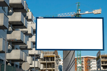 Obraz premium Advertising billboard mock-up near the construction site of modern apartment buildings