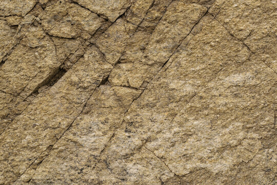 Shale massif texture with quartz inclusions. Surface of slate rock is cut by diagonal cracks, abstract background, high resolution.
