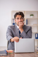 Young male employee sitting in the office