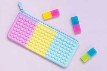 Beautiful combination of pastel shades. Purple, pink, yellow and blue. Top view of a children's pencil case and erasers