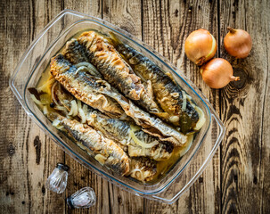 Fish dish - marinated fried herrings on wooden table
