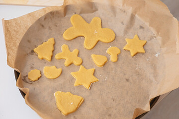 On the parchment are figurines made of raw dough in the form of Christmas symbols