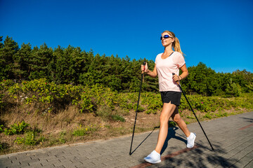 Nordic walking - young woman training
