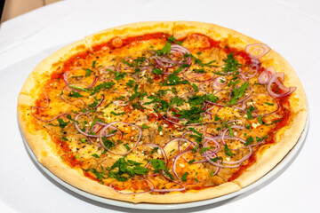 Delicious pizza with tuna, pickled onions, cheese and tomato sauce. Isolated on white.