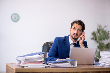 Young male employee and too much work in the office