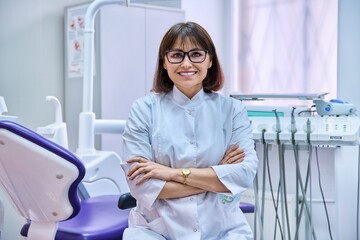 Fototapeta premium Portrait of confident female dentist doctor in office looking at camera