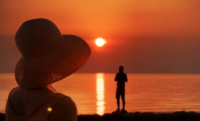 women in straw hat on orange sea sunset on horizon man silhouette watching  sun dawn nature landscape romantic summer background