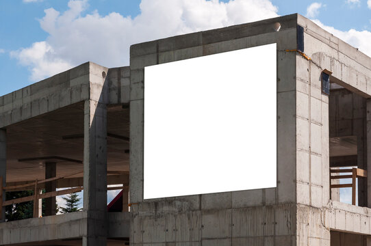 Blank white advertising banner on the facade of building under construction