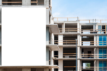 Blank white banner for advertisement on the facade of building under construction