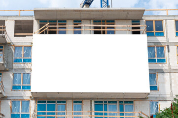 Blank white banner for advertisement on the facade of building under construction