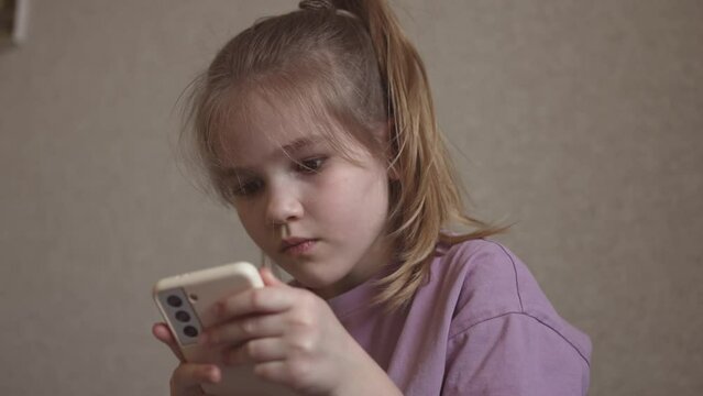 a little girl is engaged online in the application on the phone. 