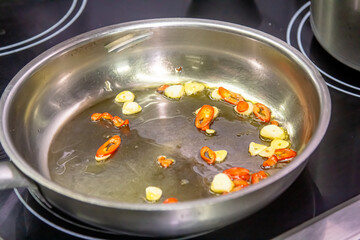 stir-fry with red pepper, typical spanish cooking, stir-fry for a paella or fideua, garlic frying in a pan with oil