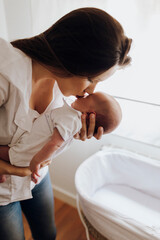 Young woman kissing newborn baby on forehead