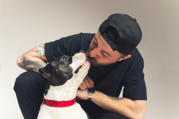 Give me a kiss. Relationship between pedigree dog and its owner. Caucasian tattooed gangster-like...