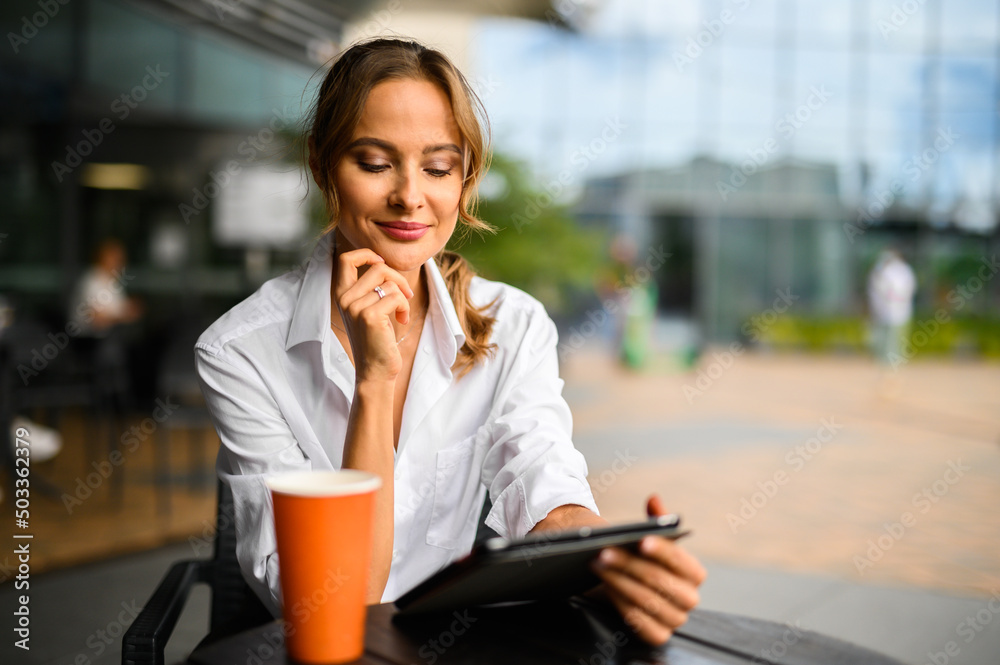 Wall mural young businesswoman on a coffee break, smiling at camera