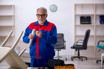 Old male carpenter repairing chair