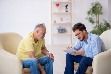 Obraz premium Old man visiting young male psychotherapist