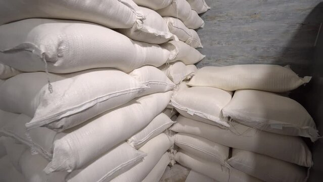 In warehouse, rice, sugar, cereals and flour are prepared in bags for shipment to consumer. Production, technological equipment, conveyor, technological plant Industrial plants. Bakery
