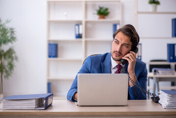 Young male employee and too much work in the office