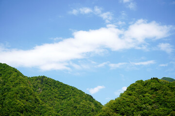 Fototapeta na wymiar 山とその背景に広がる青空と雲の風景写真・休日・北陸