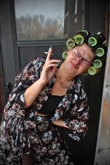 Woman in curlers smoking a cigarette