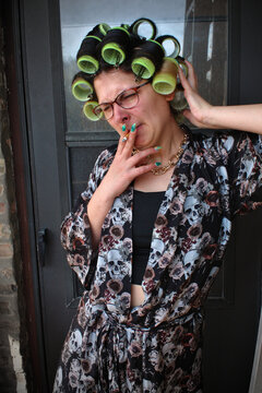 Woman in curlers smoking a cigarette