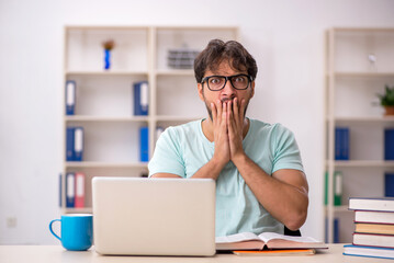 Young male student preparing for exams in the classroom