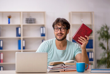 Young male student preparing for exams in the classroom