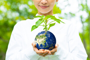 地球の模様の鉢植えを持つ女性　環境イメージ　SDGs　サステナブル - obrazy, fototapety, plakaty