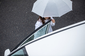 傘をさして車に乗り込もうとする女性　Rain