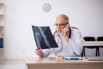 Old male doctor radiologist working in the clinic