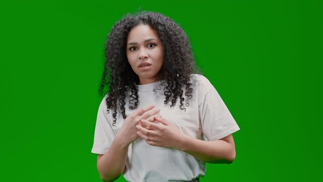 frightened woman with curly long hair dressed white tee Isolated on Green Screen