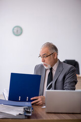 Old male employee working in the office