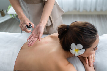 Asian young woman feeling happy and relax during back massage with oil. 