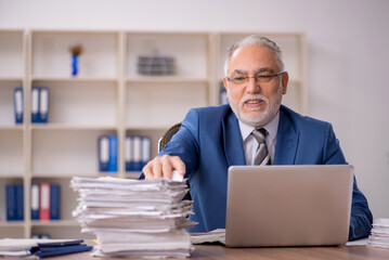 Fototapeta premium Old male employee working in the office
