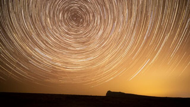 Time lapse of star trails in the night sky over Hay Tor rocks, Dartmoor National Park landscape