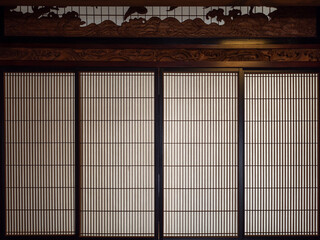 木彫りの欄間がある日本家屋の障子戸