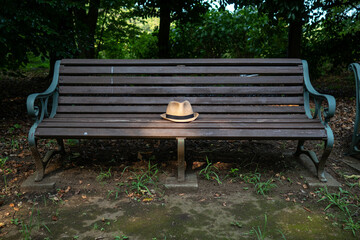 公園のベンチに置かれた帽子
