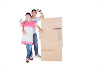 Young couple showing thumb up near cardboard box