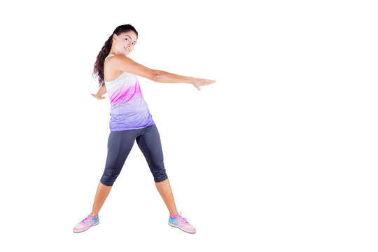 Young woman doing stretching exercise on studio